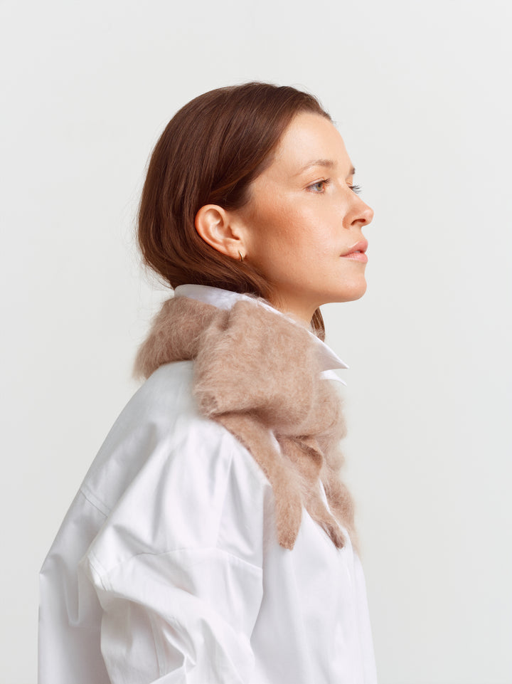 Chamonix scarf in mushroom brushed cashmere, draped over a white shirt in profile