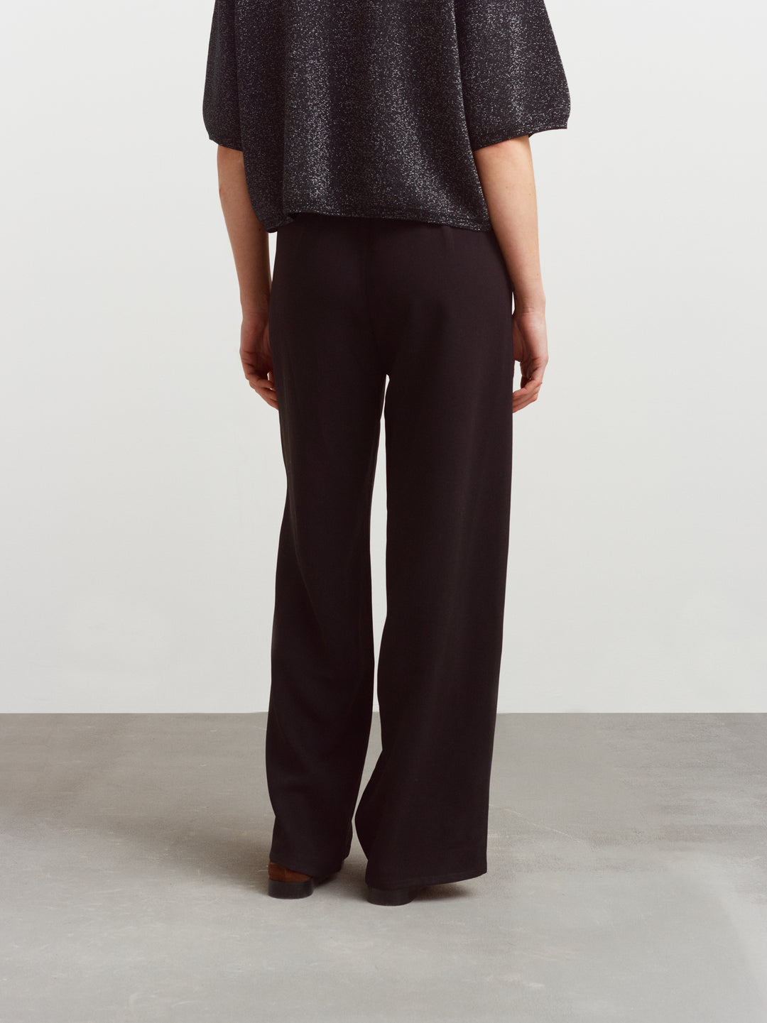 Como pull-on pant in black acetate, back view showing the fluid drape of the fabric