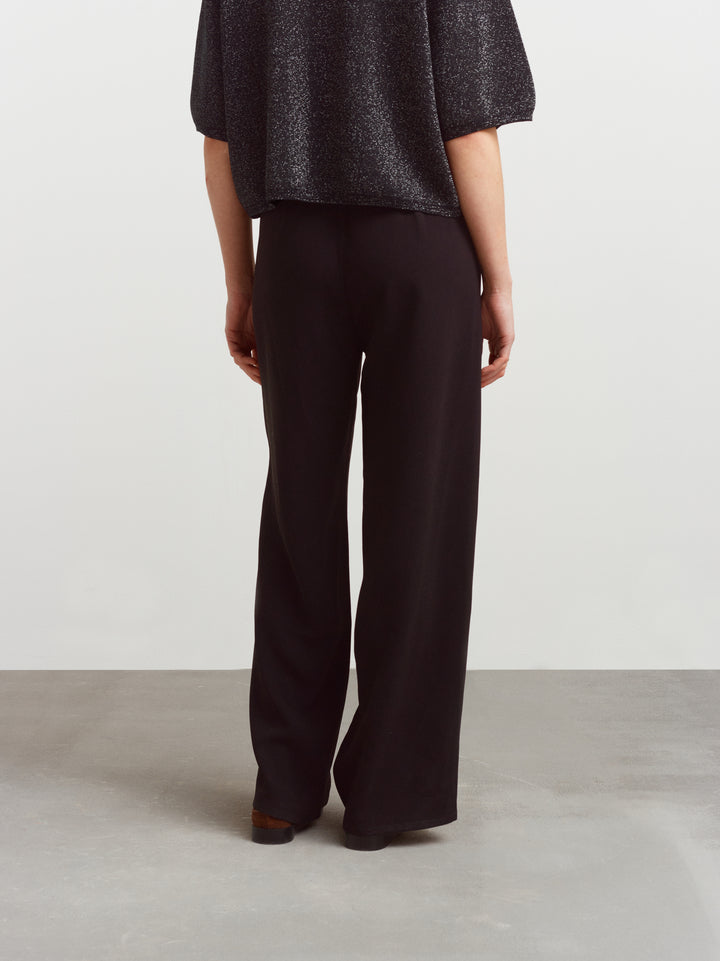 Como pull-on pant in black acetate, back view showing the fluid drape of the fabric