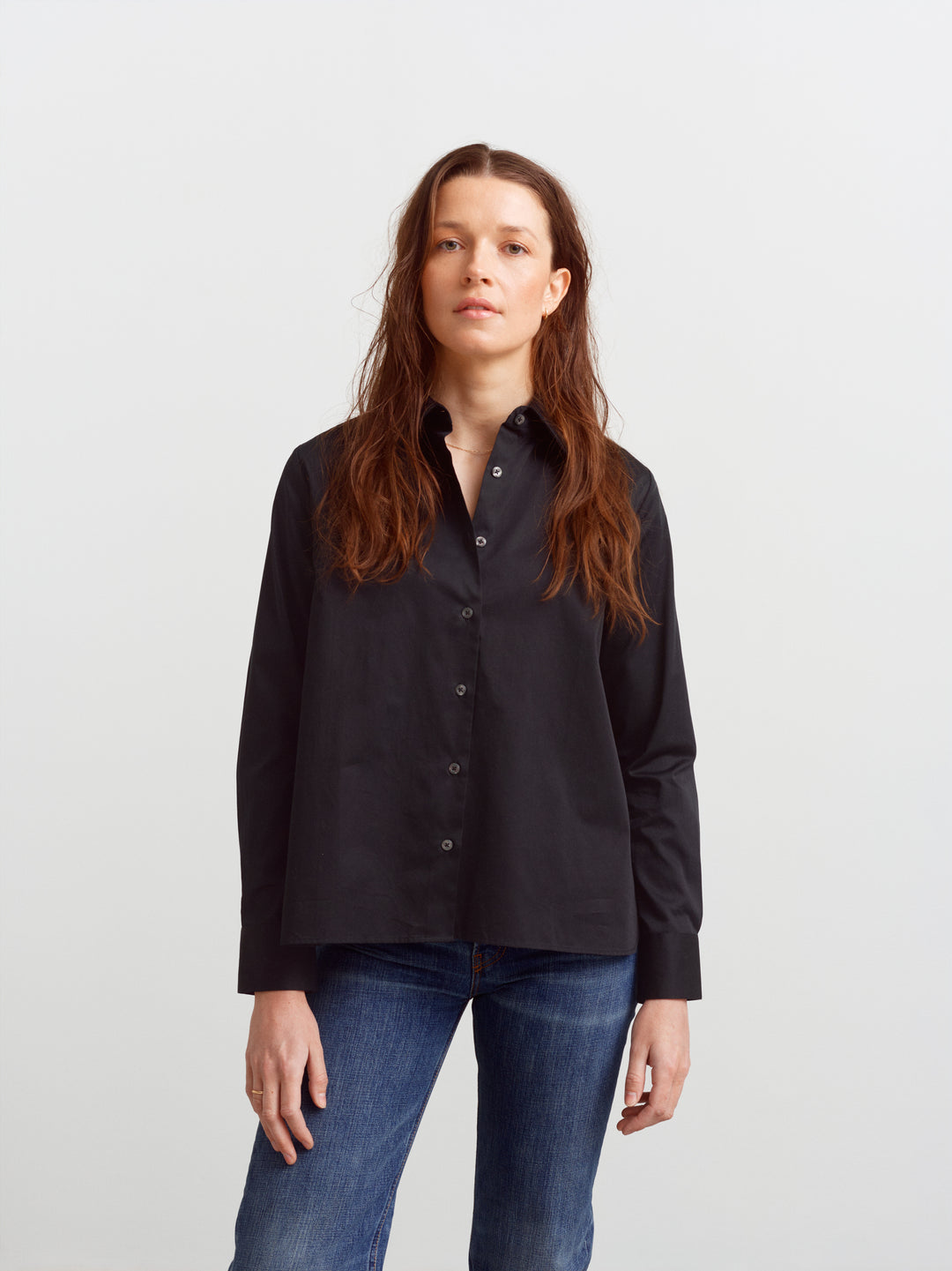 Lyon shirt in black organic cotton, front view buttoned over denim