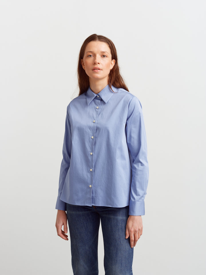 Lyon shirt in Monday blue organic cotton, front view buttoned over denim