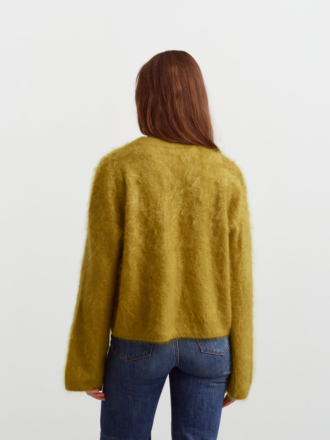 Montreal sweater in fresh moss brushed cashmere, back view showing relaxed fit over denim
