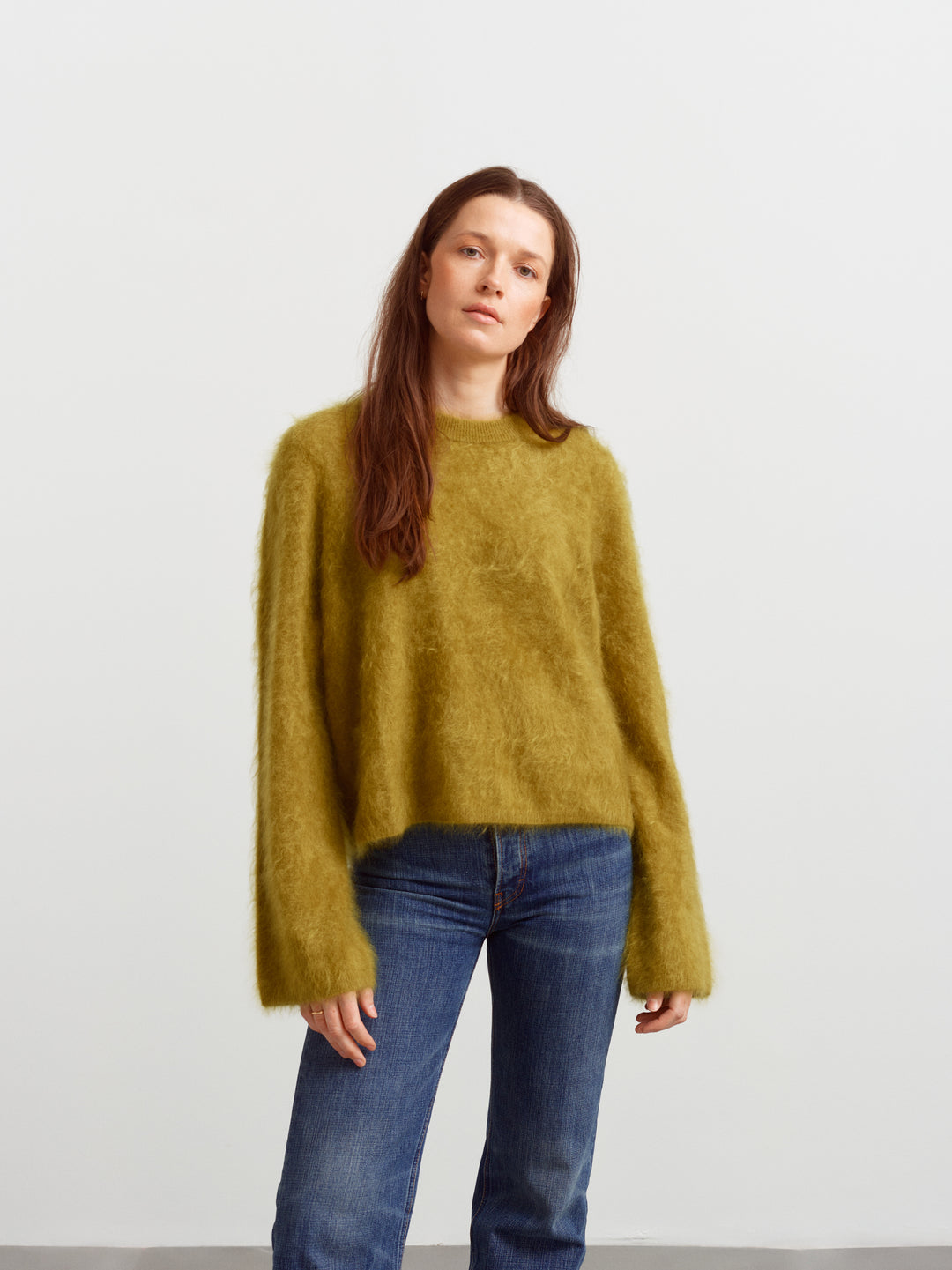 Montreal sweater in fresh moss brushed cashmere, front view with long sleeves over blue jeans