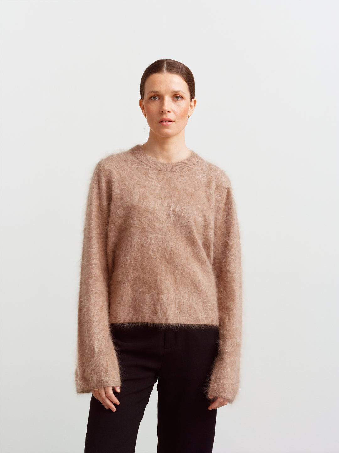 Montreal sweater in mushroom brushed cashmere, front view with crew neckline over black trousers