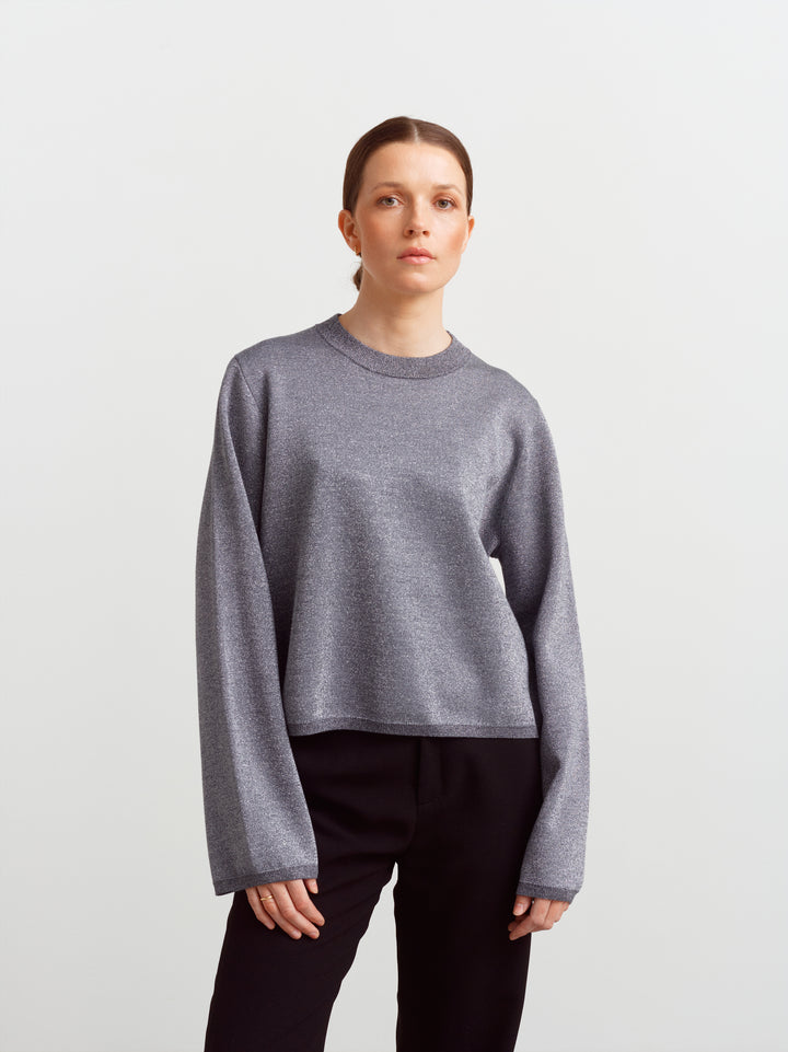 Montreal sweater in gun metal glow lurex knit, front view with straight fit over black trousers