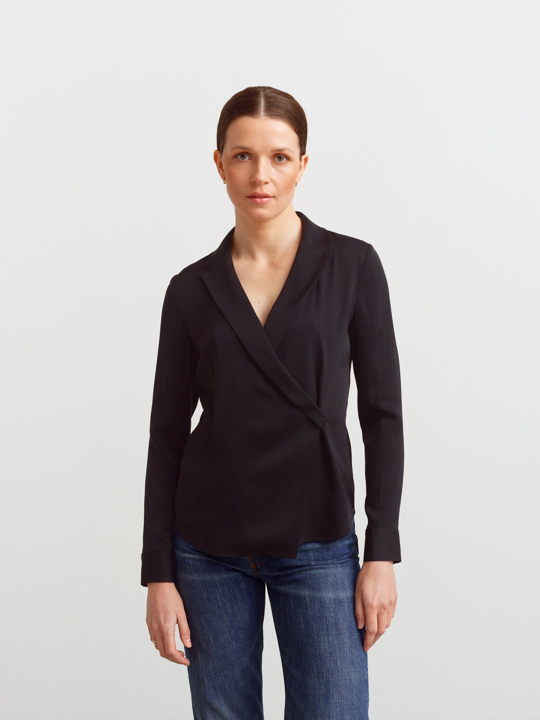 New York blouse in black silk blend, front view showing shaping through the waist over denim