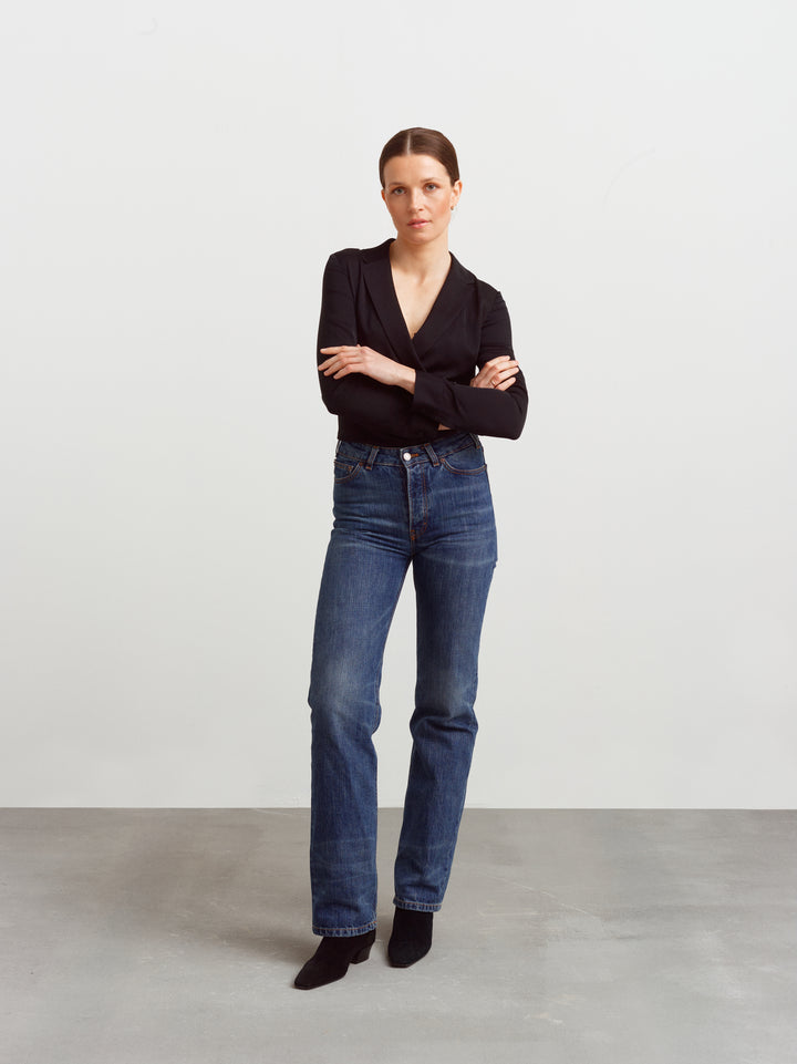 New York blouse in black silk blend, wrap front with arms crossed, worn with blue jeans