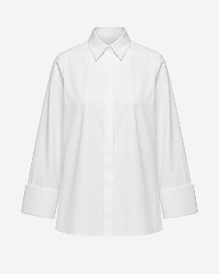 Odense shirt in white organic cotton, flat lay showing wide turn-up cuffs and pointed collar