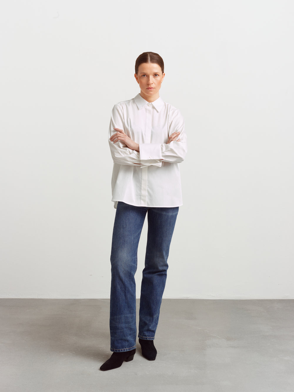 Odense shirt in white organic cotton, relaxed fit with arms crossed, worn with blue jeans