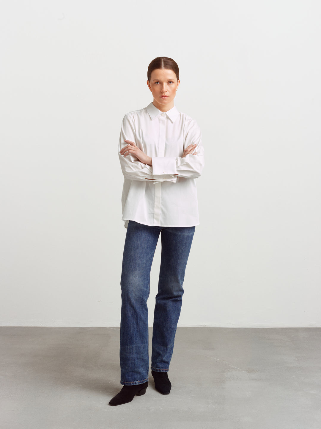 Odense shirt in white organic cotton, relaxed fit with arms crossed, worn with blue jeans