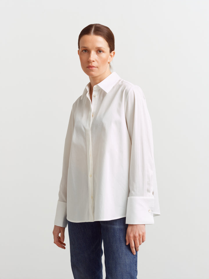 Odense shirt in white organic cotton, three-quarter view showing relaxed drape and side seam
