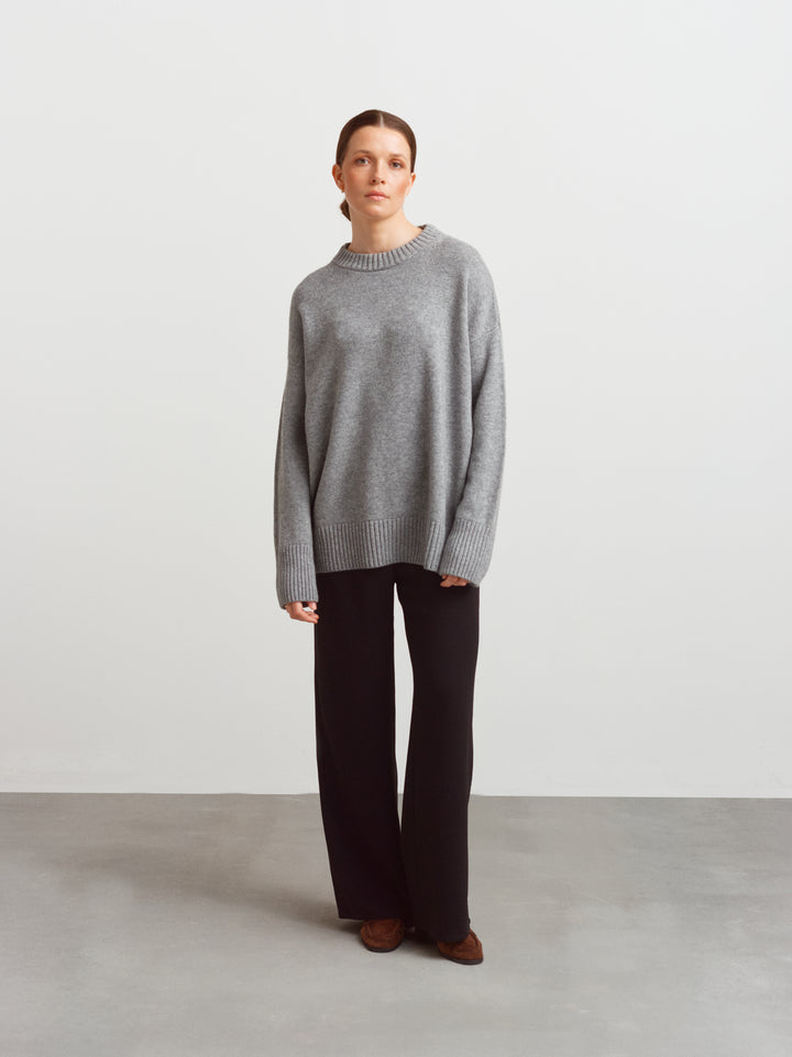 Varese oversized wool cashmere sweater in mineral grey, worn with black wide-leg trousers
