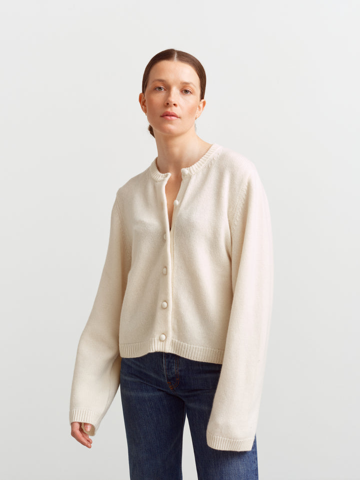 Verona cardigan in cloud dancer, front view buttoned with sleeves resting at the wrist