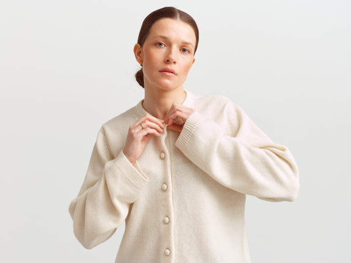 Verona soft wool cashmere cardigan in cloud dancer, hands at the collar showing volume in the sleeves